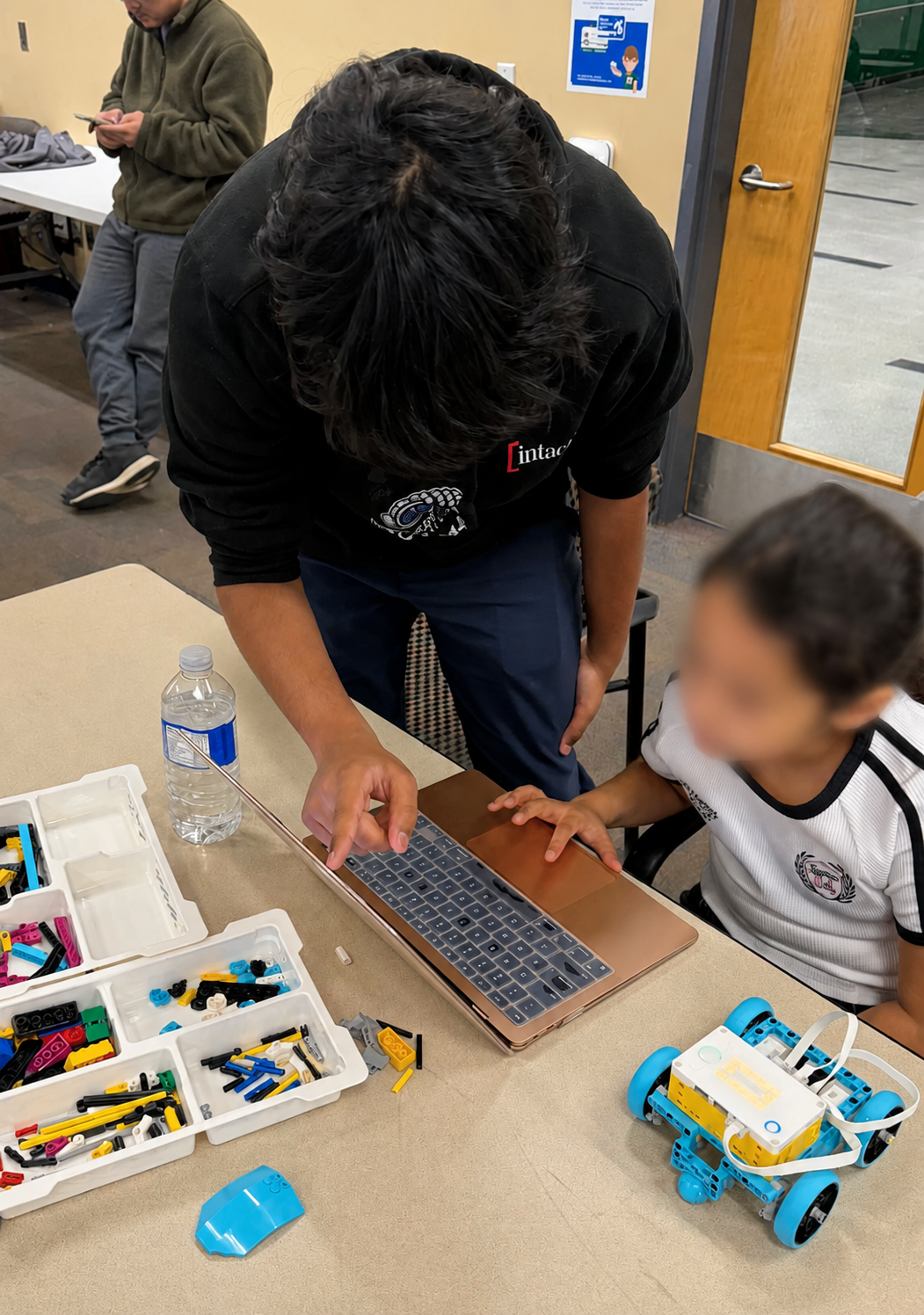 Northern Star Robotics member mentoring a young student at the IEEE LEGO Robotics Competition in Ottawa